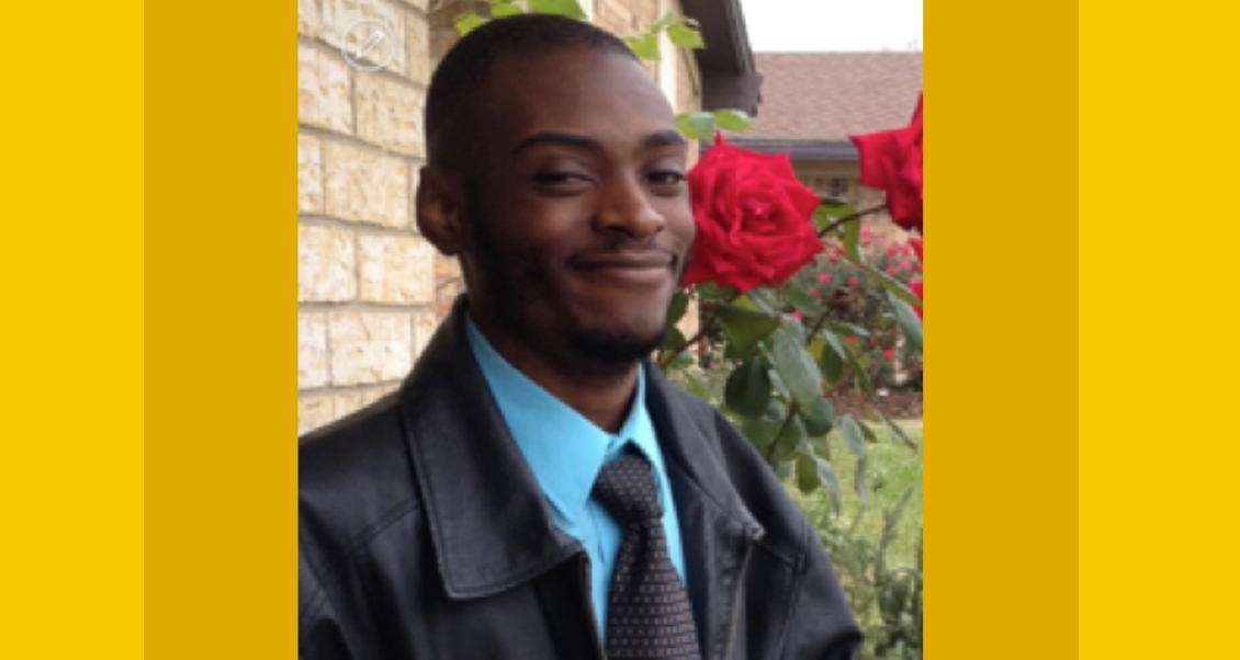 Mr. Musonda smiling in front of a rose bush