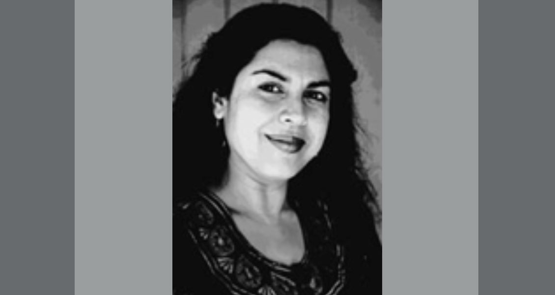 Headshot of Dr. Divakaruni, head tilted to the right and smiling. 
