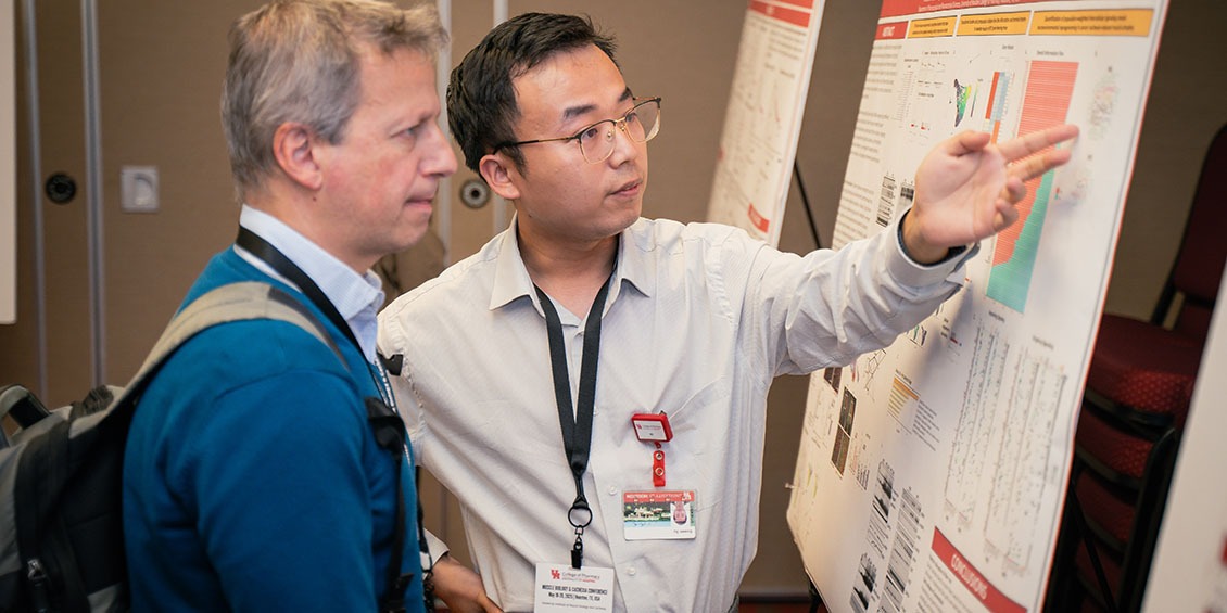 photo of poster presenter and attendee at MBCC 2025
