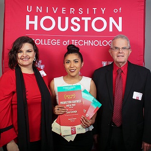 Student Rosa Cornejo holding awards while standing between professors Monika Alters and Jerry Waite.